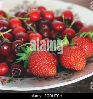 Erdbeeren und Kirschen auf einem Teller. Beerenernte Stockfoto