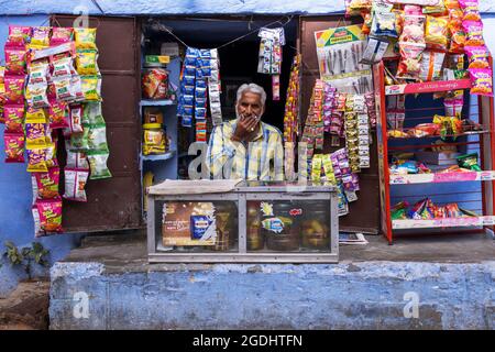 Jodhpur, Indien - 28. Februar 2018: Ein indischer Verkäufer wartet in seinem Lebensmittelgeschäft auf Kunden. Stockfoto