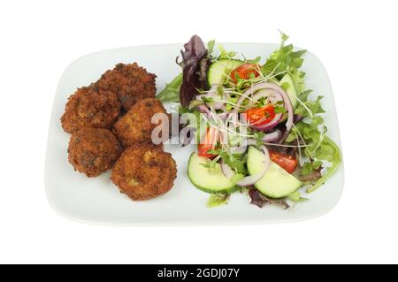 Falafel und Salat auf einem Teller, isoliert gegen Weiß Stockfoto