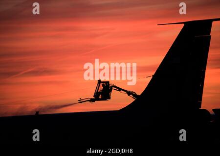 Technik. Sgt. Joshua Nordeen, Pennsylvania Air National Guard, enteitert am frühen Morgen ein Flugzeug, als die Sonne in Pittsburgh, am 12. Dezember 2019, aufgeht. (USA Foto der Air National Guard von Staff Sgt. Bryan Hoover) Stockfoto