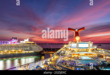 Port Canaveral, Florida, USA - 5. September 2019: Carnival Liberty und Disney Dream Schiffe dockten bei Sonnenuntergang in Port Canaveral an. Wunderschöne rote Ora Stockfoto