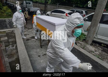 Denpasar, Bali, Indonesien. August 2021. Arbeiter werden das tote Opfer aus dem Isolationsraum holen. Die Leichenhalle des Wgaya Krankenhauses ist überlastet, da die Zahl der Toten von Covid-19 deutlich zunimmt. Die balinesische Hindu-Tradition wartet darauf, dass der ausgewählte „gute Tag“ für die toten Opfer eingeäschert wird. Wie am Donnerstag, dem 12. August, hat die Provinz Bali in 24 Stunden 1.353 neue Fälle und 35 Tote zu vermehren. (Bild: © Dicky BisinglasiZUMA Press Wire) Stockfoto