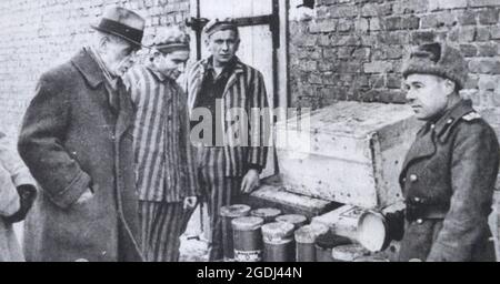 Sowjetischer Offizier und ehemalige Häftlinge des Konzentrationslagers Auschwitz II (Birkenau) in der Nähe von Kisten mit Behältern mit Stockfoto
