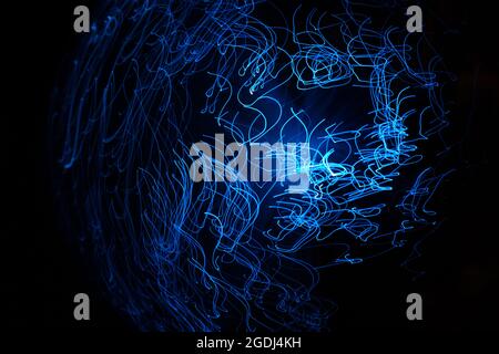 Blaue abstrakte Partikel und Linien mit Bokeh und Unschärfe in dunklem Hintergrund. Stockfoto