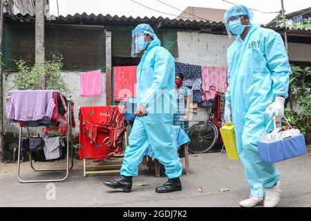 Colombo, Sri Lanka. August 2021. Gesundheitsbeamte der srilankischen Armee gehen am 13. August 2021 während der mobilen Impfkampagne gegen das Coronavirus (Covid-19) in Colombo, Sri Lanka, in ein Wohngebiet. (Foto: Saman Abesiriwardana/Pacific Press/Sipa USA) Quelle: SIPA USA/Alamy Live News Stockfoto