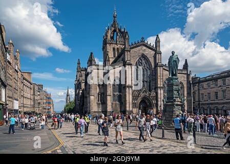 Touristen, die an der St Giles Cathedral an der Royal Mile in der Altstadt von Edinburgh vorbei laufen. Stockfoto