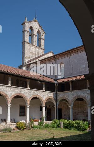 Die Kirche mit dem Glockenturm steht über dem Innenhof des mittelalterlichen Klosters des Hl. Franziskus in Pula, Kroatien. Stockfoto