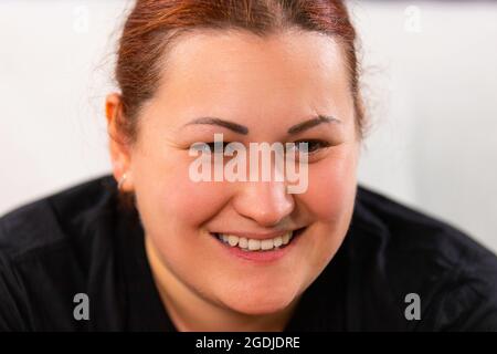 Nahaufnahme Foto einer schönen Frau Gesicht lächelnd beobachten einige nette Informationen im Fernsehen und sie sieht sehr ruhig. Stockfoto