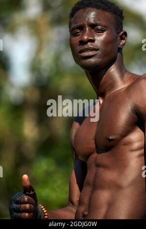 Der schwarze Sportler zeigt einen Dummy während des Trainings, Outdoor-Übungen, Afroamerikaner trainieren auf dem Sportplatz, in einer städtischen Umgebung, Nahaufnahme, Co Stockfoto