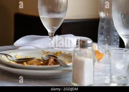 Nahaufnahme des fertigen Abendessens mit Tellern und Gläsern auf dem Tisch in einem Restaurant Stockfoto