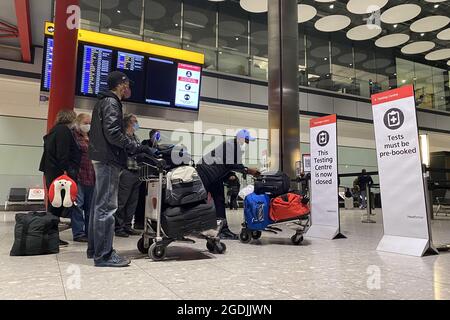 Das Aktenfoto vom 18/01/21 von Passagieren, die vor dem Testing Center in der Ankunftshalle des Terminals 5 am Londoner Flughafen Heathrow Schlange stehen. Die Kosten für Reisetests von NHS Test und Trace für Menschen, die aus dem Ausland nach Großbritannien kommen, sollen gesenkt werden, sagte das Gesundheitsministerium. Es soll von £88 nach £68 für Reisende aus Großbritannien, die aus Ländern der grünen Liste kommen, oder diejenigen, die aus Ländern der gelben Liste gekommen sind und vollständig geimpft wurden, gehen. Ausgabedatum: Freitag, 13. August 2021. Stockfoto