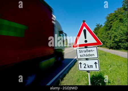 schild 'Vorsicht 2 km Straßenschaden' am Straßenrand, Deutschland Stockfoto