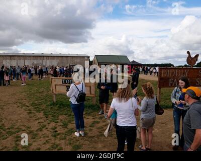 Leute, die draußen Schlange stehen, um im beliebten Jeremy Clarkson's Diddly Squat Farm Shop, Chipping Norton Road, Chipping Norton, West Oxfordshire einzukaufen Stockfoto