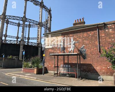 Gasometer oder Gashalter, aus Gusseisen und Stahl gebaut, Banksy-Kunstwerke über einer Busstation in Admiralty Road, Great Yarmouth, Norfolk, England, Großbritannien Stockfoto