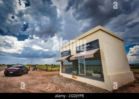 Ein Texas State Trooper spricht mit einem Motorradfahrer in der Nähe dieser „Kultur“ von Prada Marfa, die wie ein Prada-Geschäft in Marfa, Texas, im Norden des Landes aussieht Stockfoto