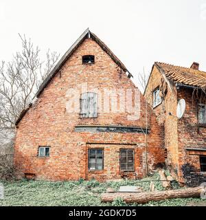 Fassade eines alten deutschen Ziegelhauses mit verbrannter Wand in schlechtem Zustand Stockfoto
