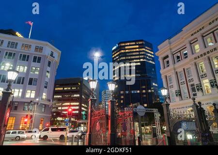 Wellington New Zealand   July 27 2021;beleuchtete kommerzielle Skyline der Stadt vom Ufer aus mit hohen Gebäuden mit Lichtern und Straßenlaternen von außen Stockfoto