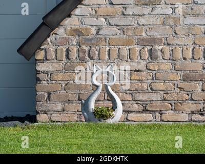 Betonsilhouette einer großen Katze mit Blumen als Gartendekoration Stockfoto