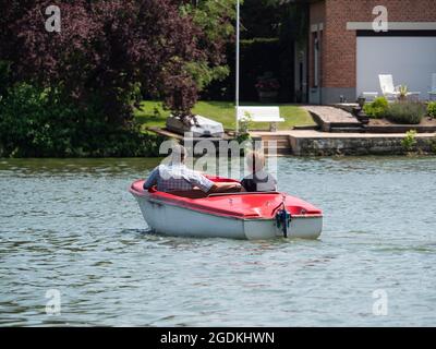Ältere Paare genießen eine Bootsfahrt auf einem See mit einem Elektroboot Stockfoto