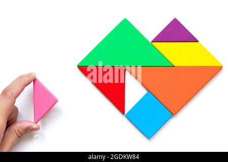 Farbe Holz Tangram Puzzle in Herzform warten zu erfüllen Auf weißem Hintergrund Stockfoto