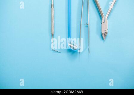 Draufsicht beschnittene Nahaufnahme von Zahnarztwerkzeugen auf blauem Hintergrund, Copyspace Stockfoto