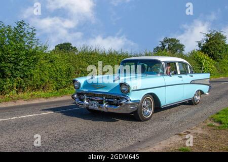 1957 50er Jahre blau weiß amerikanischer Chevrolet GMC Chevy Bel-Air 4dr Limousine auf dem Weg zur Capesthorne Hall Classic Car Show im Juli, Cheshire, Großbritannien Stockfoto