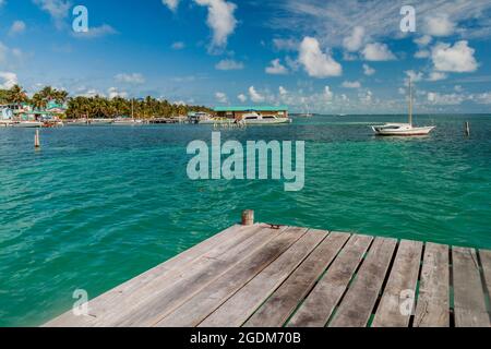 Blick auf Caye Caulker Dorf von einem hölzernen Pier, Belize Stockfoto