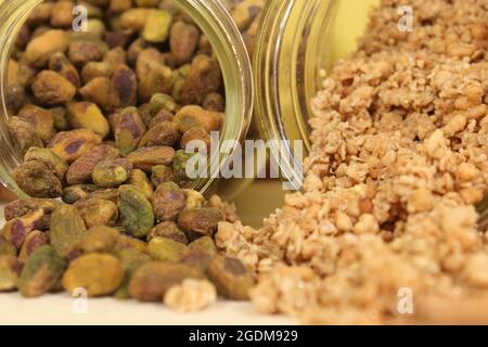 Pistazien und Mischnüsse mit Bio-Müsli auf Holztisch Stockfoto