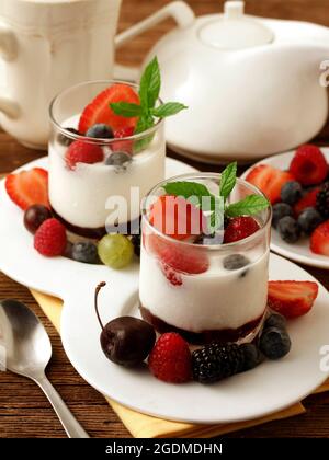 Joghurt mit Beeren. Kirschen, Himbeeren, Brombeeren, Heidelbeeren, Stachelsbeeren, Erdbeeren. Stockfoto