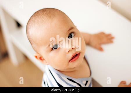 Cute kleines Baby mit großen dunklen Augen und langen Wimpern. Süßes Kleinkind zu Hause Stockfoto