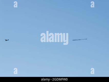 Leichtes Flugzeug, das am klaren blauen Himmel über Queensland, Australien, ein Banner mit der Aufschrift „Herzlichen Glückwunsch, es ist ein Junge“ zieht. Speicherplatz kopieren. Hintergrund. Stockfoto