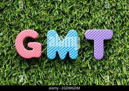 Farbe Alphabet Buchstaben in Wort GMT (Abkürzung von Greenwich Mean Time) auf Kunstrasen Hintergrund Stockfoto