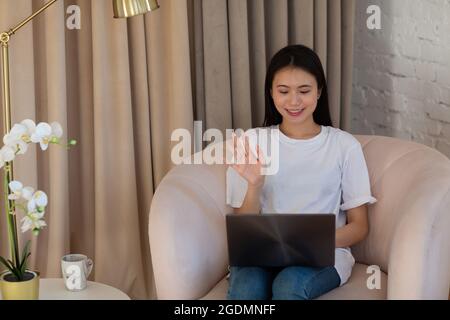 Portrait der asiatischen Frau genießen mit Laptop in Wohnung innen Wohnzimmer. Video Call vlogger Webinar Stream Konzept Stockfoto