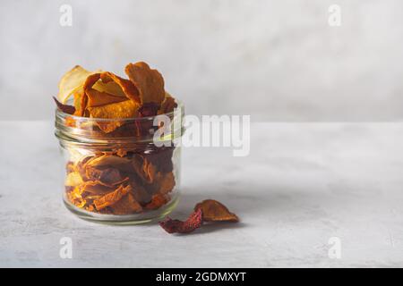 Gemüseschnitzel von Kartoffeln, Rüben und Karotten in einem Glas und auf einem betonierten Hintergrund. Speicherplatz Kopieren Stockfoto