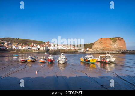 Fischerboote haben bei Ebbe im Hafen von Staithes, North Yorkshire, geerdet. Stockfoto