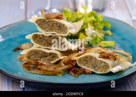 Hälften schwäbische maultaschen Pasta mit Salat Stockfoto