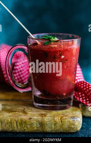 Sommerdessert mit Bio-Wassermelonenpopsicles auf Teller mit Eis und Rosmarin serviert Stockfoto