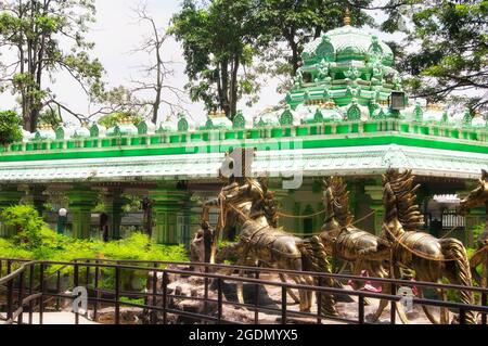 goldene Pferde vor einer großen Statue von lord krishna am Eingang der ramayana-Höhle in der malerischen Batu-Höhle Gombak, Selangor Malaysia. Stockfoto