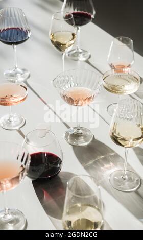 Gläser Rot-, Rose- und Weißwein auf weißem Hintergrund mit Schattierungen Stockfoto