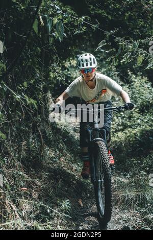 Portrait-Action-Aufnahme einer fokussierten Mountainbiker-Frau, die auf einem Trail unterwegs ist Stockfoto