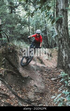 Fokussierte Mountainbiker-Frau, die auf dem Trail eine Kurve nimmt Stockfoto