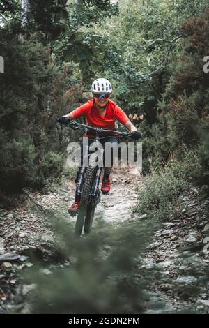 Rahmenfüllendes Actionportrait einer jungen Frau auf dem Mountainbike auf dem Trail Stockfoto