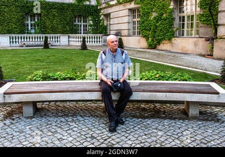 Staatsbibliothek Berlin – älterer Mann sitzt auf der Bank auf dem Vorplatz der größten wissenschaftlichen Forschungsbibliothek Deutschlands, unter den Linden 8,Mitte,Berlin Desig Stockfoto