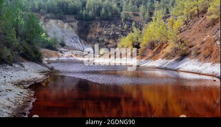 Ufer des giftigen roten Sees im Tagebau der alten Kupfermine in einem Wald, Zypern Stockfoto