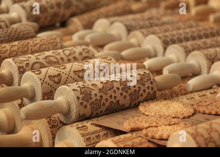 Eine Ausstellung von hölzernen Rollnadeln mit verschiedenen Designs und Plätzchen. Stockfoto