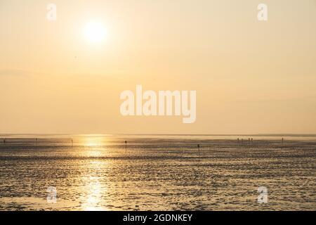 Sonnenuntergang über dem Wattenmeer, Nationalpark Niedersächsisches Wattenmeer, UNESCO-Weltkulturerbe. Nordseeküste Ostfrieslands, Deutschland. Stockfoto