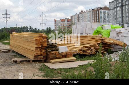 Stapel von vielen Holzplanken auf einer Baustelle, Baustoff Hintergrund. Renovierung, Dachüberschneidung, Bau und Hauskonzept. Holzstangen Stockfoto