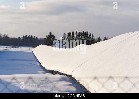Solarpanel Feld mit Schnee bedeckt. Erneuerbare Energie im Winter niedrige Effizienz. Erneuerbare grüne Energie Industrie Konzept im Winter. Stockfoto