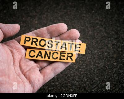 Ein Mann, der gelbe Papierstücke mit den Worten Prostatakrebs in der Hand hält. Nahaufnahme. Stockfoto