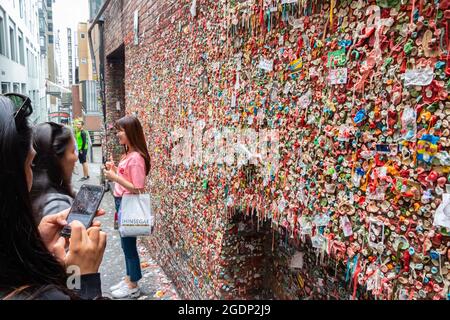 Touristen fotografieren die Touristenattraktion Seattle Chewing GUM Wall in der Nähe des Pike Place Market in Seattle, USA Stockfoto